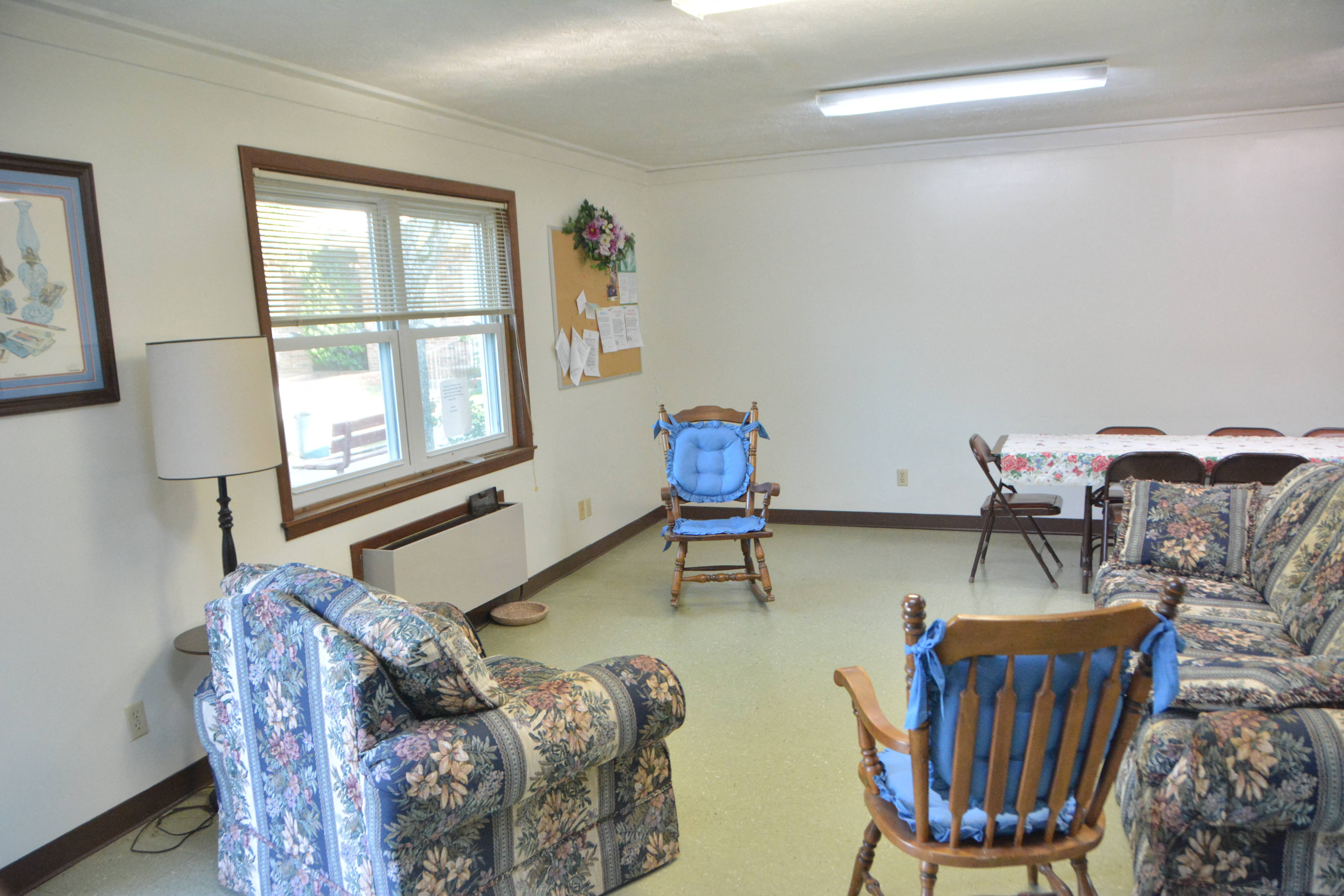 a living room with couches and chairs and a table with a bed